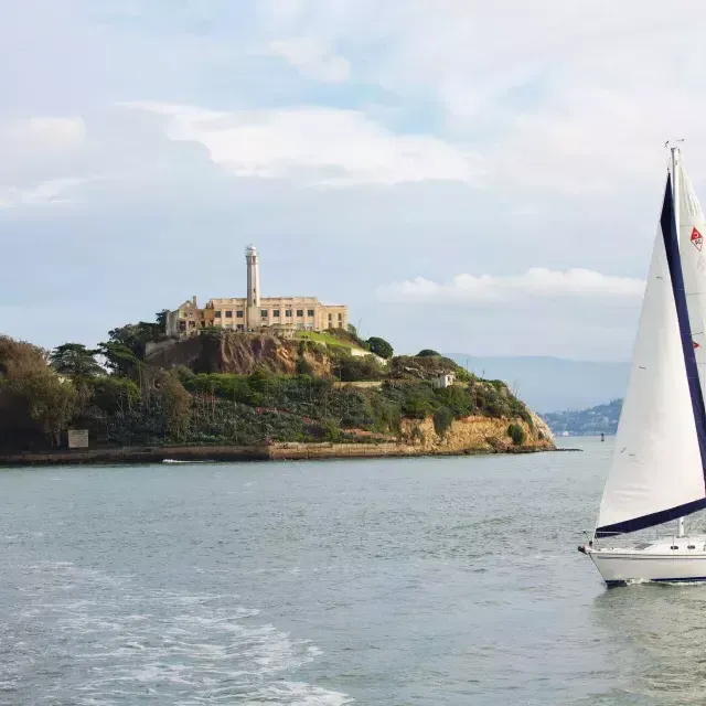 A sailboat passes in front of 阿尔卡特拉斯岛 Isl和 in San Francisco.